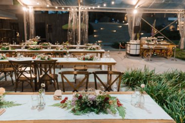 Düğün resepsiyonu akşam yemeği masası ve güzel bir çiçek süslemesi..