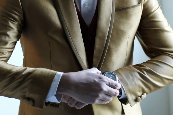Szczegóły Stanowią Pół Ciała Człowieka Złotym Garniturze Trzymając Zegarek Lub — Zdjęcie stockowe