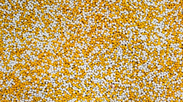 Plastic pellets white and yellow for texture background material design.