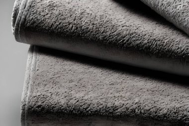 Close up clean gray folded towel stack each other.