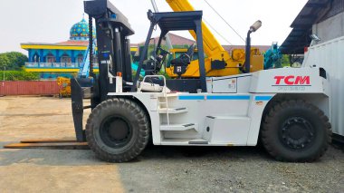 Jakarta, Indonesia - July 18, 2022: Side view large 23 Tons FD230 capacity TCM forklift parking at the yard.
