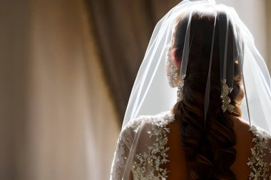 Beyaz gelinlik giymiş bir gelin arkadan yaklaşıyor..