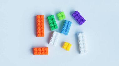 Tuğla ya da pastel yapı taşı ya da çocuklar beyaza izole edilmiş renkli plastik bloklar yapıyorlar..