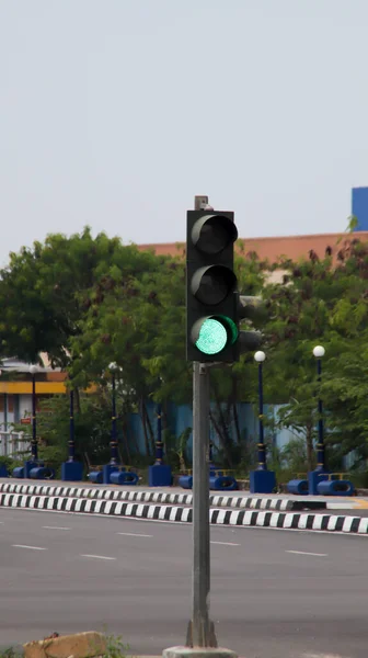 Green traffic light at the road intersection.