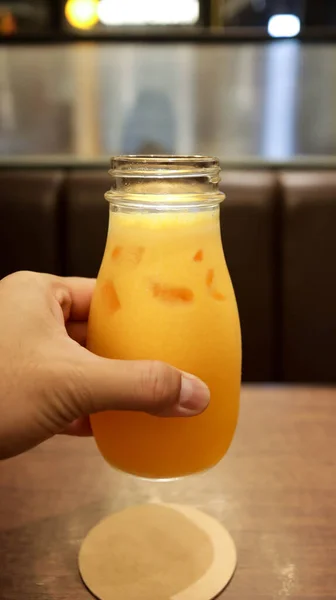 Een Hand Die Gezond Geel Sinaasappelsap Vasthoudt Een Glazen Fles — Stockfoto