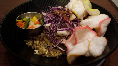 Bir tabak kızarmış pirinç, karides krakeri, mor lahana sebzesi, sahanda yumurta ve biraz turşu..