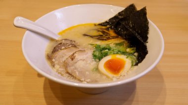 Bir kase Buta Tonkotsu Ramen Eriştesi yağlı domuz çorbası, taze erişte, yumurta sarısı ve kuru yosun malzemeleriyle ağızda eriyen yumuşak domuz göbeği..