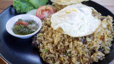 Nasi Goreng Kampung ya da geleneksel Endonezya Kızarmış Pirinci, tavuklu kızarmış pirinç, yumurta, sambal ve krakerle servis edilen Asya yeşili.