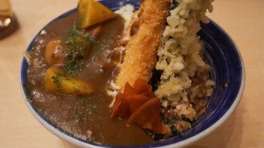 Curry Ebi Furai Don tereyağlı pilav üzerine kızarmış köri soslu mozzarella peyniri ve deniz yosunundan oluşan bir Japon yemeğidir..