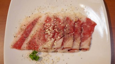 Izgara, barbekü ve sıcak çömlek için beyaz tabakta taze et ya da domuz eti. Japon Wagyu Yakiniku biftek dilimi.