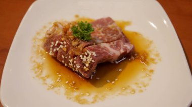 Izgara ya da barbekü için beyaz tabakta tereyağlı soya soslu taze biftek ya da domuz eti. Japon Wagyu bifteği..
