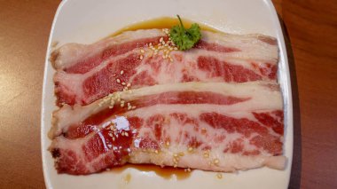 Izgara, barbekü ve sıcak çömlek için beyaz tabakta taze et ya da domuz eti. Japon Wagyu Yakiniku biftek dilimi.