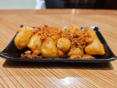 Altın Çıtır Kızarmış Tofu Sarımsak Baharatlı Kara Tabak, Tahta Masa Arkaplanı