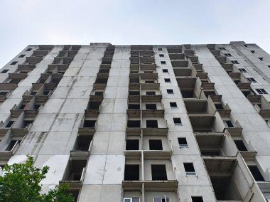 Şehir Bölgesi 'nde terk edilmiş yüksek binalar, Bulutlu Gökyüzü Altında Beton Cephe, Şehir Çürümesini Yansıtan