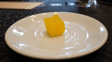 Close-up of Yellow Crystal Rock Sugar on White Plate with Patterned Background clipart