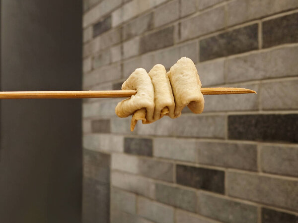 Крупный план нарезанного корейского рыбного торта Eomuk на фоне кирпичной стены