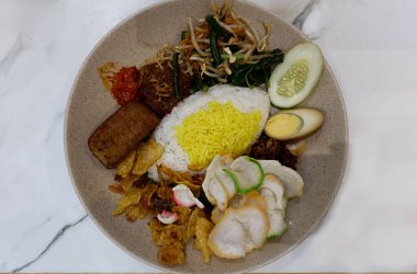 Sarı Pirinç, Tempeh, Sambal, haşlanmış yumurta, Rendang, Sebze ve Kraker ile geleneksel Endonezya Kampüsü