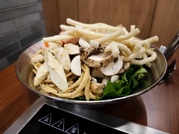 stock image Fresh Variety of Vegetables and Mushrooms in a Stainless Steel Bowl on a Restaurant Table Ready for Cooking