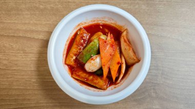 Baharatlı kırmızı soslu çeşitli sebzeli Kore Banchan Tahta Masa üzerinde beyaz seramik kasede