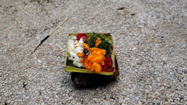 Bali 'deki Geleneksel Hindu Ritüelleri için Çakıl Arazisinde Renkli Çiçeklerle Güzel Düzenlenmiş Bali Sepetleri.