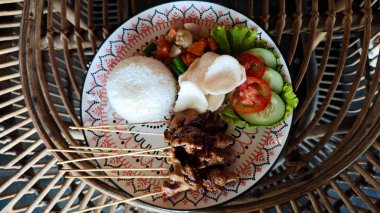 Geleneksel Endonezya Pilavlı Satay Tabağı, Taze Sebzeler, ve Fıstık Sosu Rattan Masası Dekoratif Tabağı Üzerinde Canlı Renkler