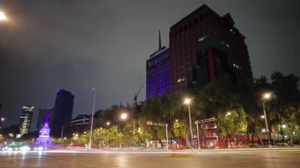 メキシコ市内の建物や車に囲まれたPaseo Reforma AvenueにあるCuitlahuac Monumentの夜のハイパーラップ — ストック動画