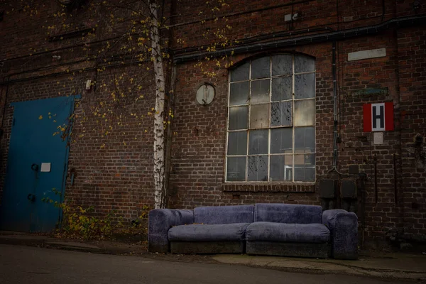 old sofa in front of a historic warehouse