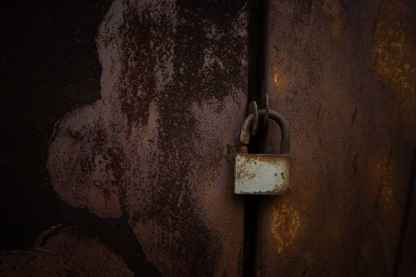 Rusty padlock on a metal background, selective focus
