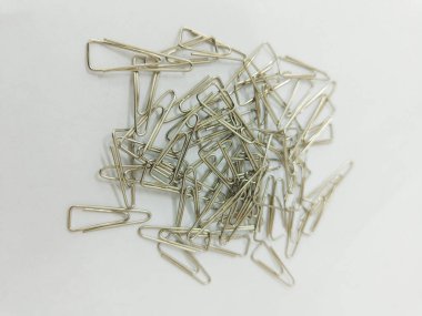 a pile of silver paper clips on the white background