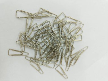 a pile of silver paper clips on the white background