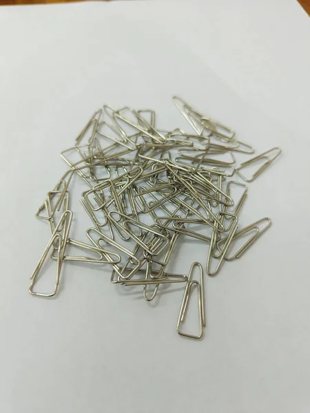 a pile of silver paper clips on the white background