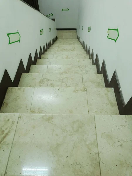 The empty stairs inside the house with white wall in each side