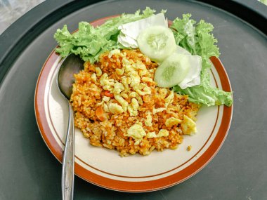 A plate of fried rice with vegetables