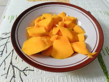 A plate of slices of mango on the table