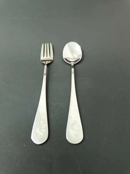 Spoon and fork set on the black background.