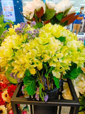 Beautiful artificial flowers and plants in the pots for indoor decoration