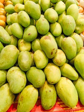 A pile of green mangoes. No people
