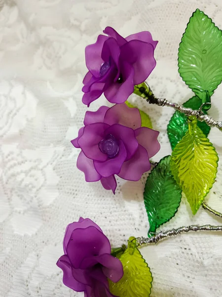 Artificial flowers on the white lace background.