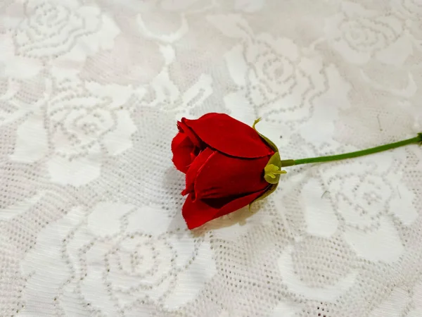 Artificial flowers on the white lace background.