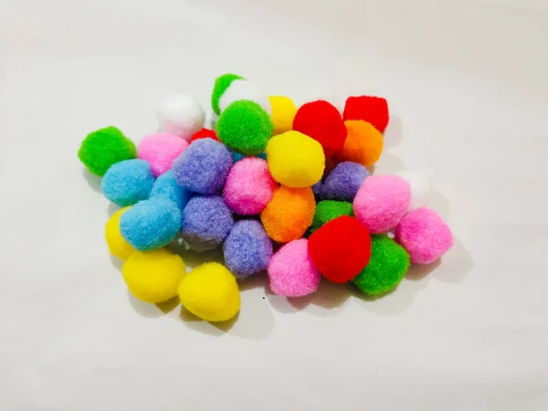 colorful pompoms on the white background. red, blue, pink, blue, and yellow color.