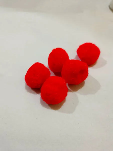 colorful pompoms on the white background. red, blue, pink, blue, and yellow color.