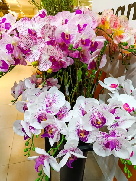 Beautiful artificial flowers and plants in the pots for indoor decoration