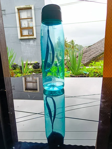 Clear blue water bottle on the glass table