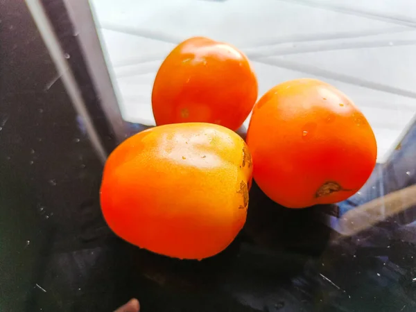 Three ripe red tomatoes on the table