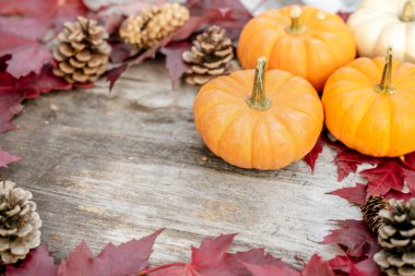 Balkabakları, kurumuş yapraklar ve ahşap arka planda sonbahar kompozisyonu. Sonbahar, sonbahar, Cadılar Bayramı konsepti. Düz konum, üst görünüm, kopyalama alanı