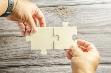 Birbirine bağlanan beyaz yapboz. Takım işi başarı ortaklığı ya da takım çalışması konsepti. Bir grup iş adamı yapboz yapıyor. İş kadını elleri yapbozu birbirine bağlıyor. İş çözümleri, başarı ve strateji kavramı. Kapat