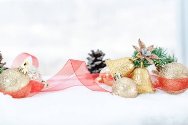 Kışın Noel 'i, kar kurdeleli Noel baloları, kış tatili konsepti. Noel kırmızı topları, altın toplar, çam ve kar taneleri kar altında süslemeler