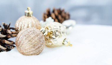 Kışın Noel 'i, kar kurdeleli Noel baloları, kış tatili konsepti. Noel kırmızı topları, altın toplar, çam ve kar taneleri kar altında süslemeler