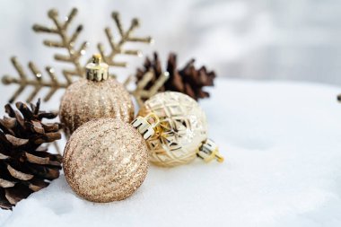 Kışın Noel 'i, kar kurdeleli Noel baloları, kış tatili konsepti. Noel kırmızı topları, altın toplar, çam ve kar taneleri kar altında süslemeler