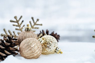 Kışın Noel 'i, kar kurdeleli Noel baloları, kış tatili konsepti. Noel kırmızı topları, altın toplar, çam ve kar taneleri kar altında süslemeler